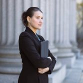 A government worker stands outside of a government building.