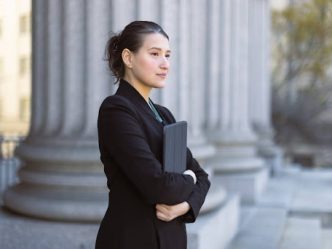A government worker stands outside of a government building.