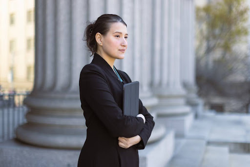 A government worker stands outside of a government building.