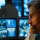 An intelligence officer examines security data on a computer.